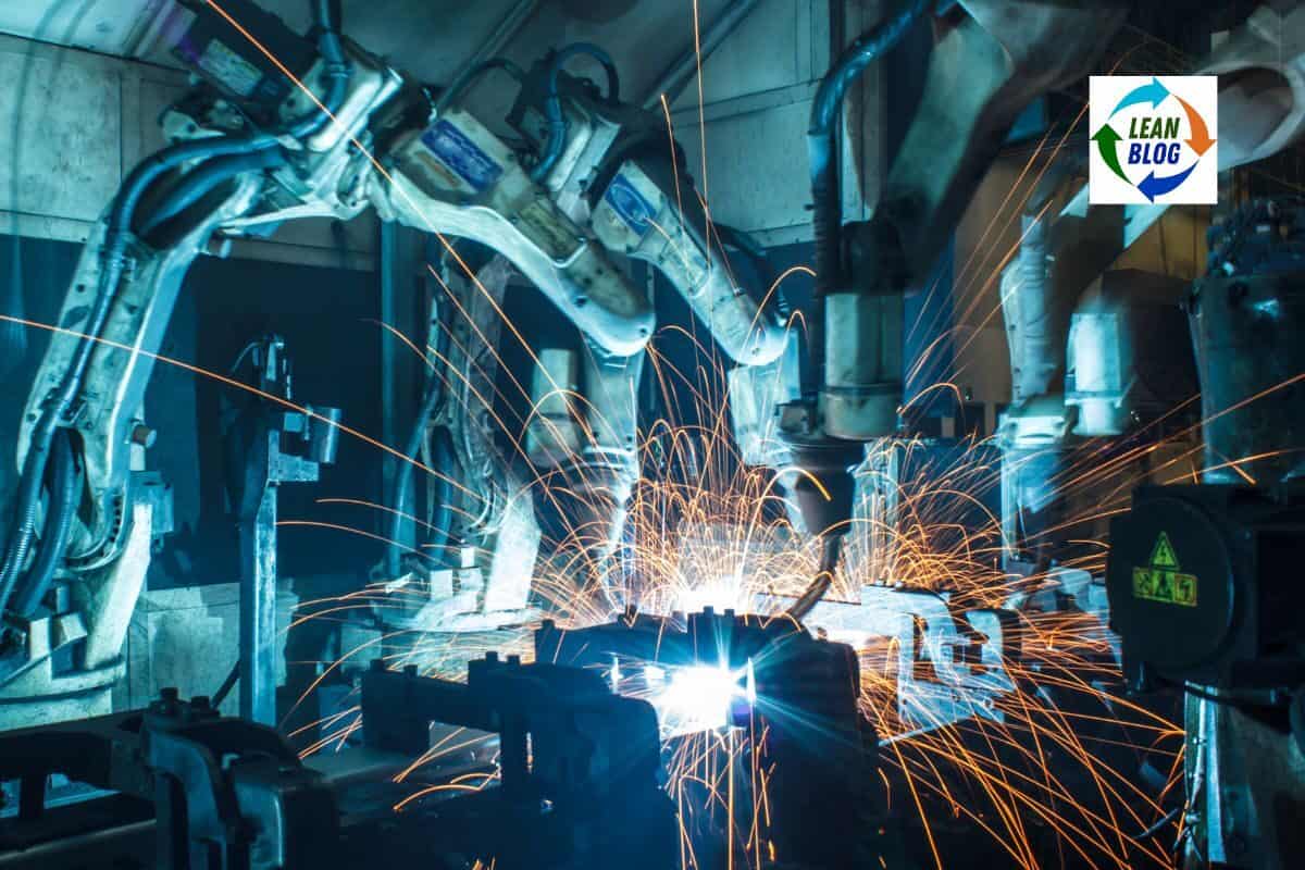 Automated industrial robots welding with sparks in a manufacturing setting.