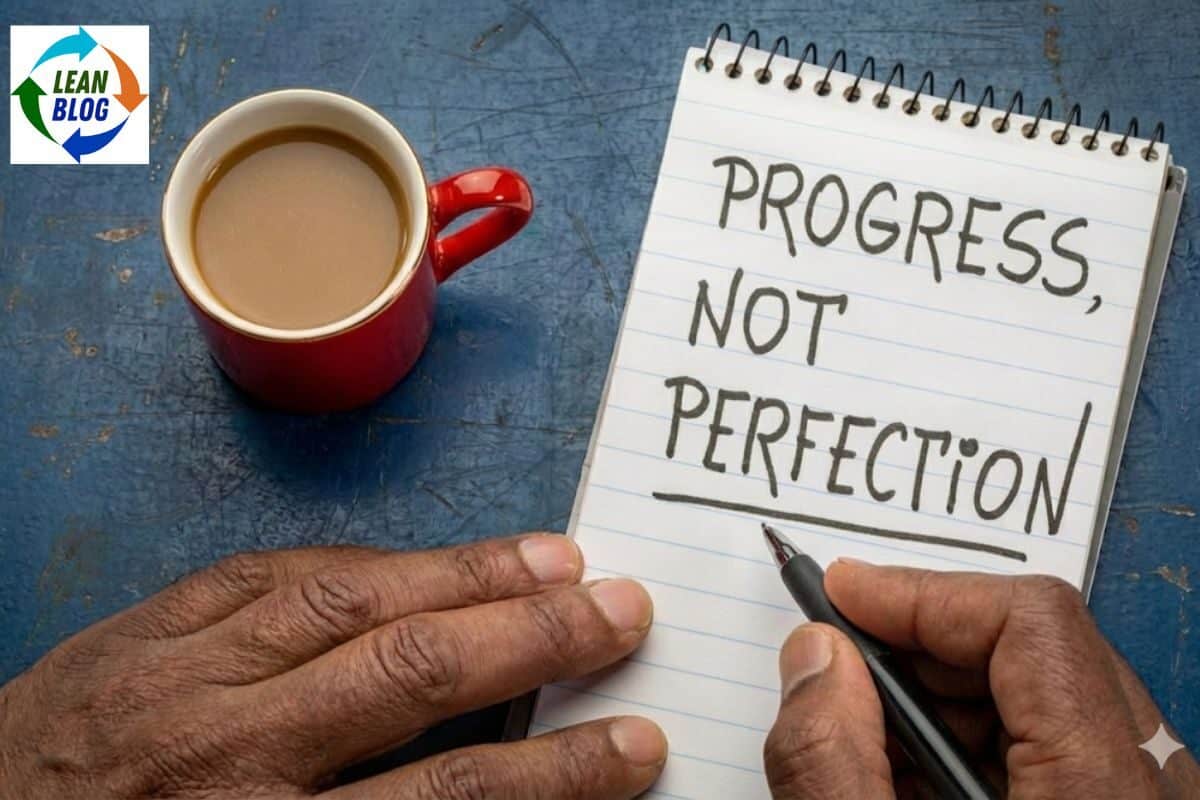 Progress, not perfection handwritten on notepad with coffee cup; emphasizes continuous improvement in Lean leadership.