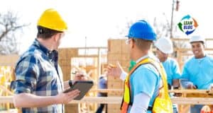 Hard hat safety conversation on a construction site with group of workers.