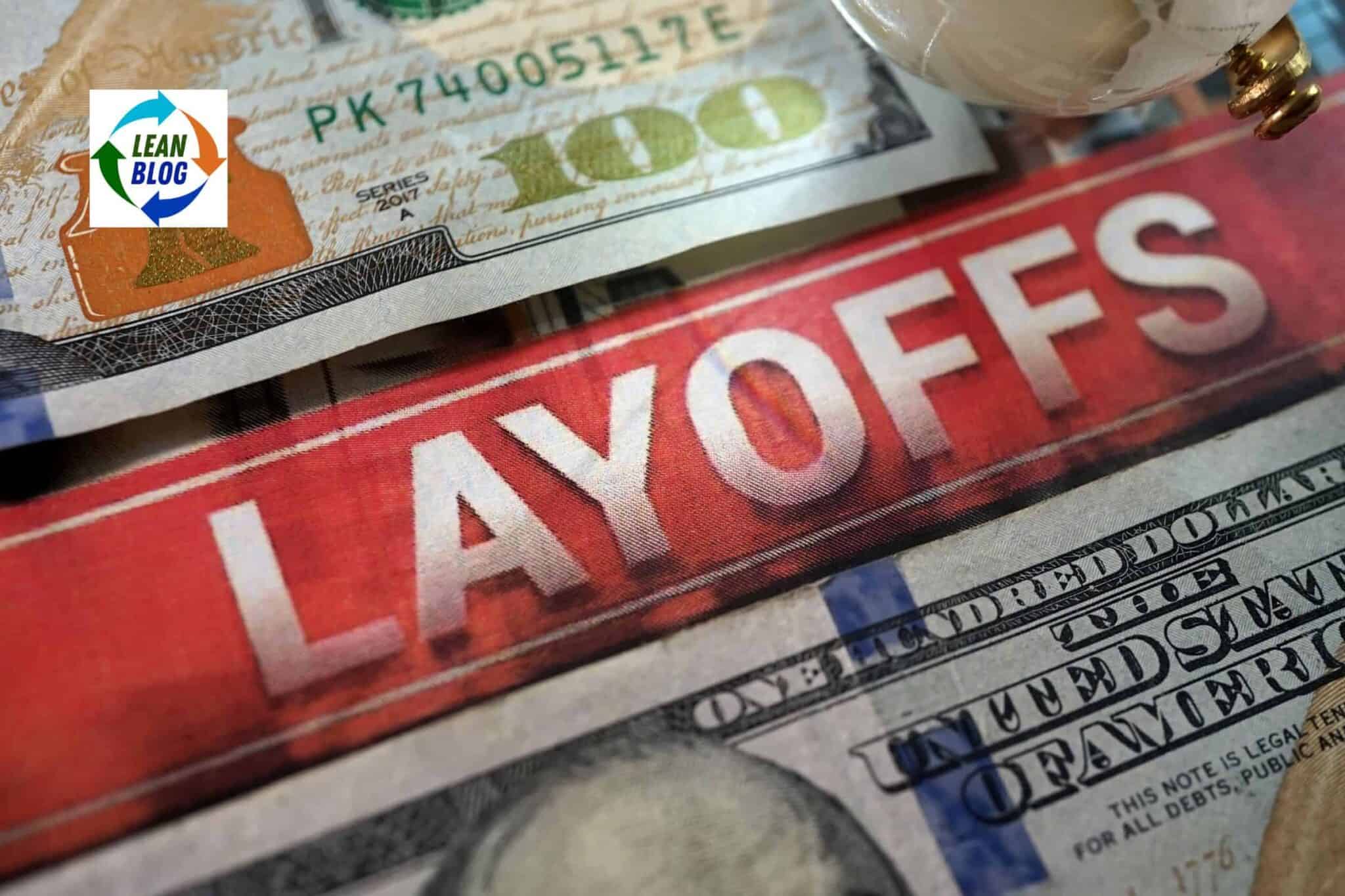 $100 bill with "LAYOFFS" written across it in bold white letters.
