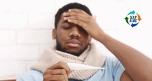 1. Man holding thermometer, appearing sick and tired in a healthcare setting.