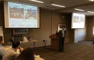 How Franciscan Health Built a Culture of Continuous Improvement Through Kaizen 1. Presenter giving lean improvement case study to hospital staff in conference room.