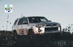 Why Lean Hospitals Should Learn from Toyota About Staffing and Layoffs 1. A silver Toyota SUV parked in a grassy field under a cloudy sky.