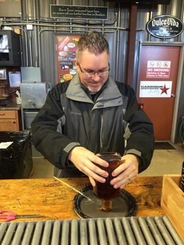 Dipping bottles in wax at Garrison Brothers Distillery