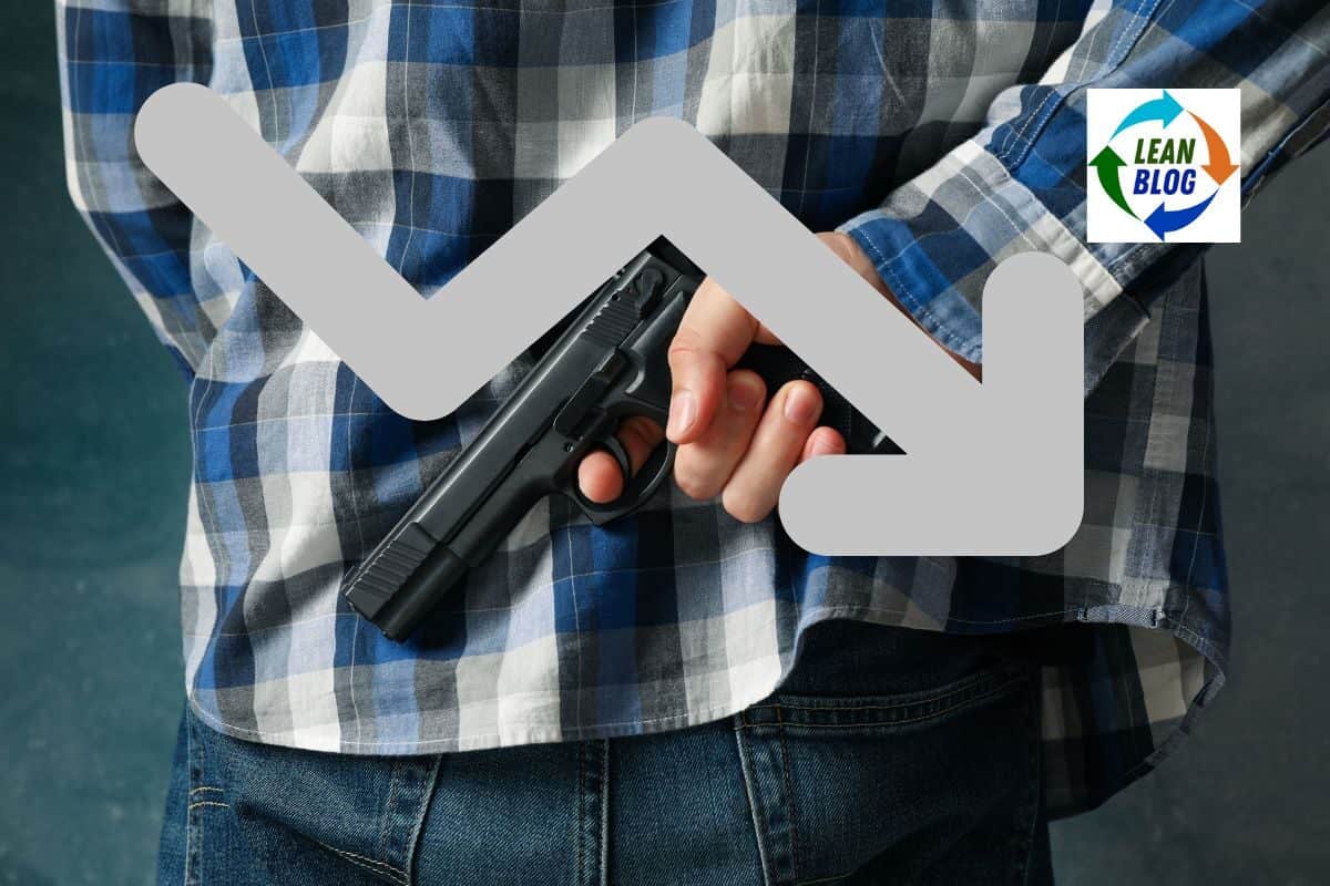 Gun pointed downward, hidden behind a tape measure, with a large grey downward arrow overlay.