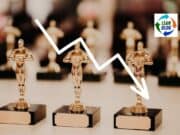 Ratings for “The Oscars” Were Lower in 2018? Should We Ask Why or Look for Longer-Term Trends? Downward trending line graphic over gold trophy figures representing decline in success or performance.