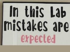 If Mistakes Are Expected, We Can React Appropriately and Constructively (and Even Prevent Them) A sign with bold text that reads "In this Lab mistakes are expected," emphasizing a culture that embraces learning from errors.