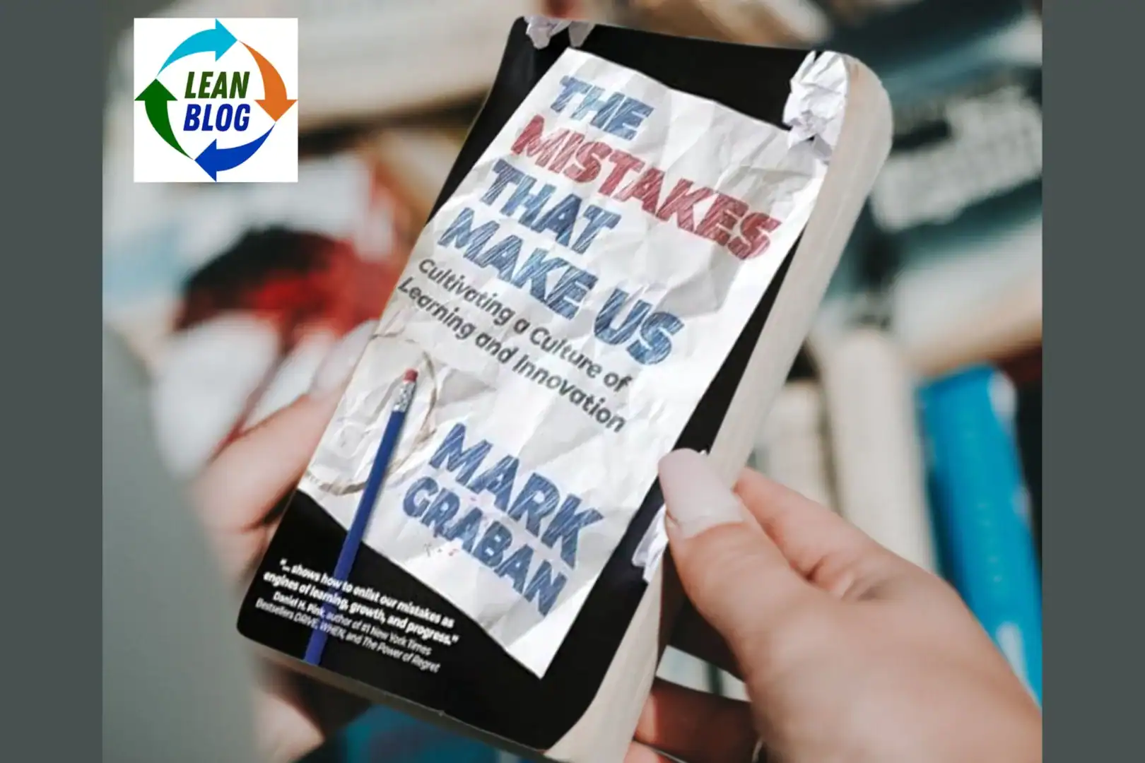 **Alt Text:** An image showing a person holding the book "The Mistakes That Make Us: Cultivating a Culture of Learning and Innovation" by Mark Graban. The book cover features a crumpled piece of paper with the title and author's name prominently displayed. The background is blurred, focusing on the book. The Lean Blog logo is displayed in the top left corner, featuring a circular design with arrows in blue, green, and orange, and the text "LEAN BLOG" in the center.