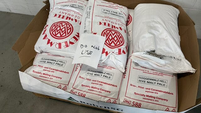 Bags of distillery rye with a paper "DO NOT USE" sign