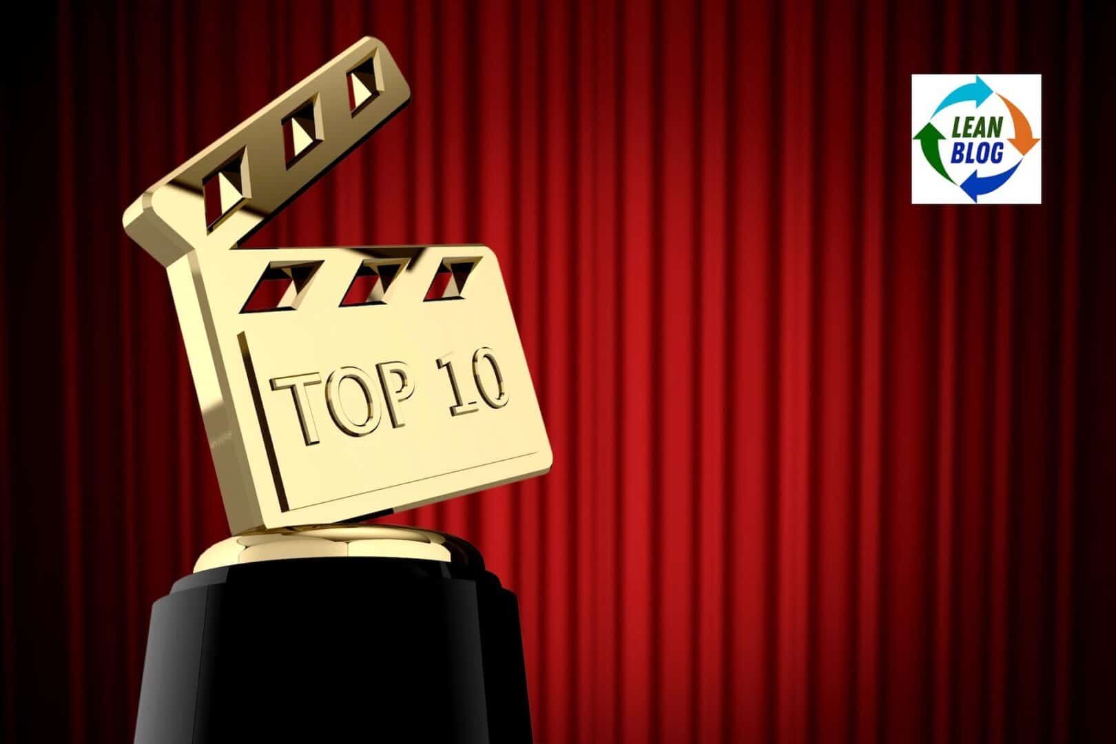 Golden top 10 movie award trophy against red curtain backdrop with Lean Blog logo.