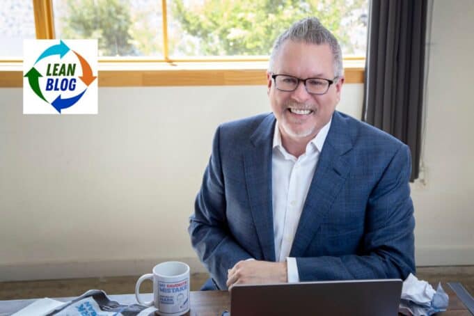 A Brief Response From Mark (The Human) Mark Graban smiling at his desk with a laptop and My Favorite Mistake coffee mug, apparently unbothered by his AI's public meltdown