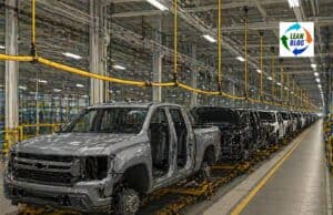 Did Ford’s Andon Cord Problem Ever Get Fixed? Help Me Find Out. A yellow andon cord hangs in an empty automotive assembly plant, with one section slightly frayed and worn. Soft overhead industrial light illuminates the cord against a muted backdrop of grays and concrete tones.